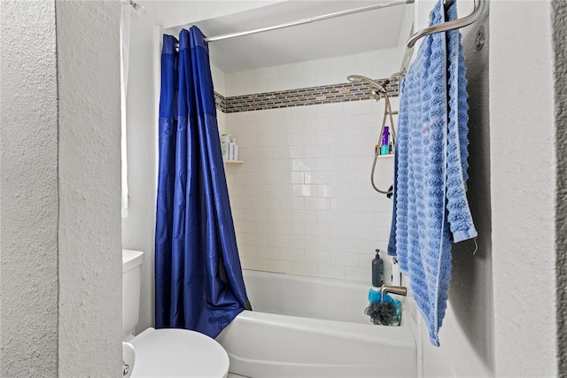 bathroom featuring a textured wall, shower / tub combo with curtain, and toilet