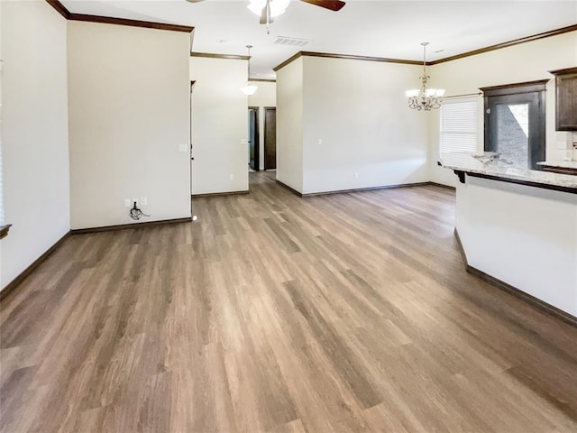 unfurnished living room featuring visible vents, light wood-style flooring, baseboards, and ornamental molding