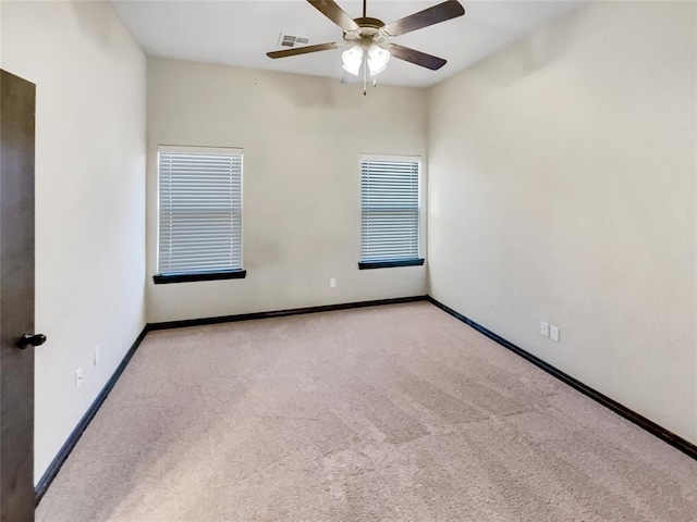 empty room featuring carpet flooring, visible vents, baseboards, and ceiling fan