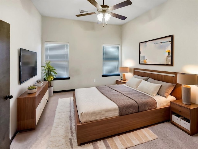 bedroom featuring visible vents, light carpet, baseboards, and a ceiling fan