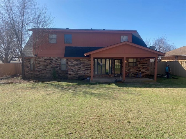 back of property with brick siding, a patio, and a fenced backyard