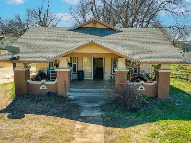 bungalow-style home with covered porch and roof with shingles