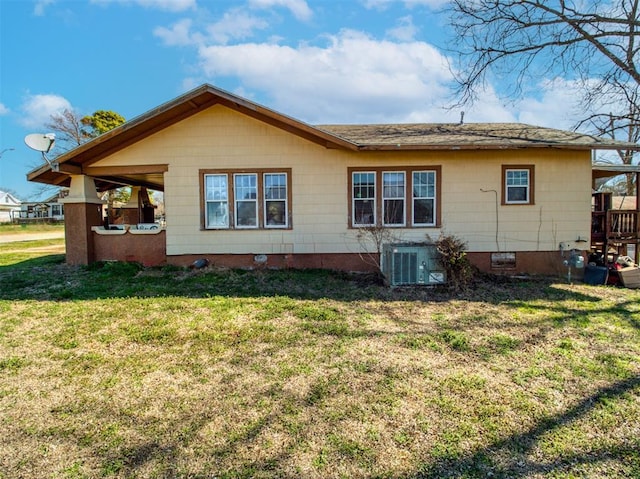 back of property with a lawn and central AC