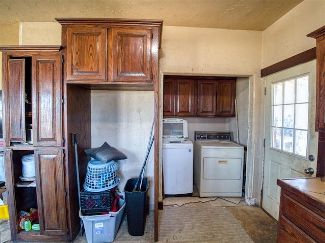 interior space with washing machine and dryer, cabinet space, and a textured wall