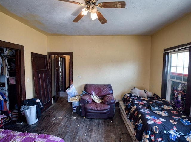 bedroom with a textured ceiling, wood finished floors, and a ceiling fan