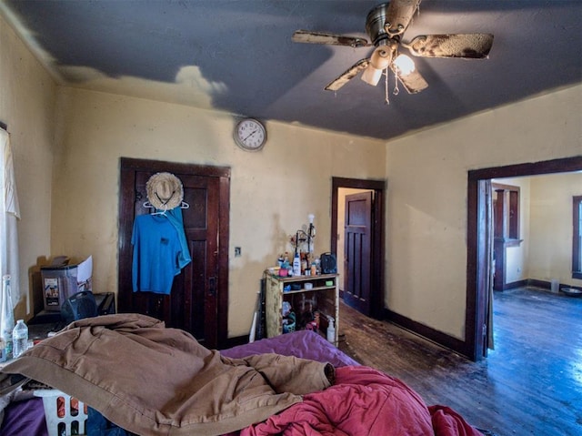 bedroom featuring ceiling fan, baseboards, and wood finished floors