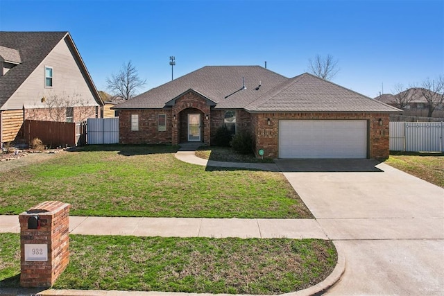 view of front of house featuring a garage, brick siding, a front lawn, and fence