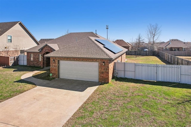 view of front of house featuring driveway, a fenced backyard, a front lawn, a garage, and brick siding