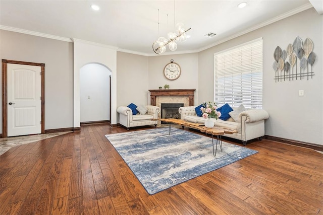 living room featuring dark wood-style floors, visible vents, baseboards, arched walkways, and crown molding