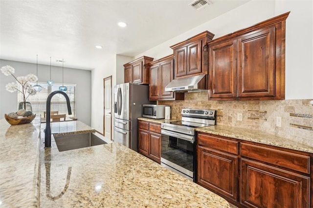 kitchen with visible vents, backsplash, under cabinet range hood, stainless steel appliances, and a sink