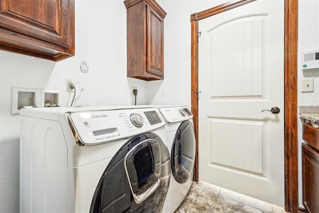 clothes washing area with washer and dryer and cabinet space