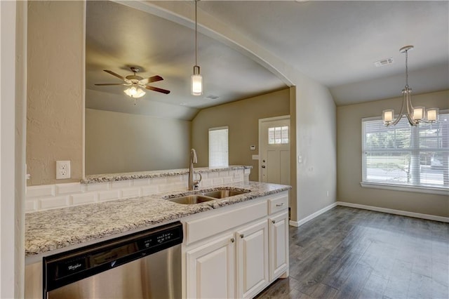 kitchen with dark wood-type flooring, a sink, light stone countertops, dishwasher, and vaulted ceiling