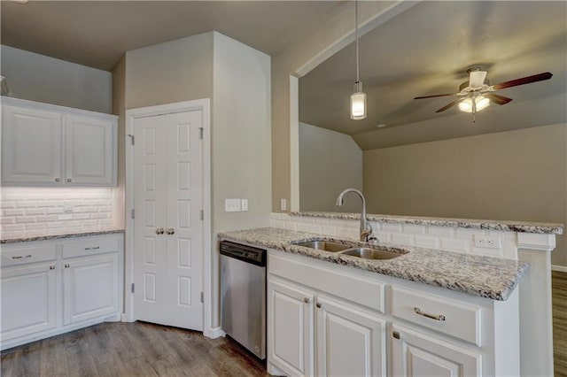 kitchen featuring a peninsula, a sink, dark wood-type flooring, white cabinets, and dishwasher