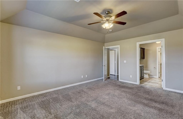 unfurnished bedroom with light carpet, connected bathroom, baseboards, ceiling fan, and vaulted ceiling