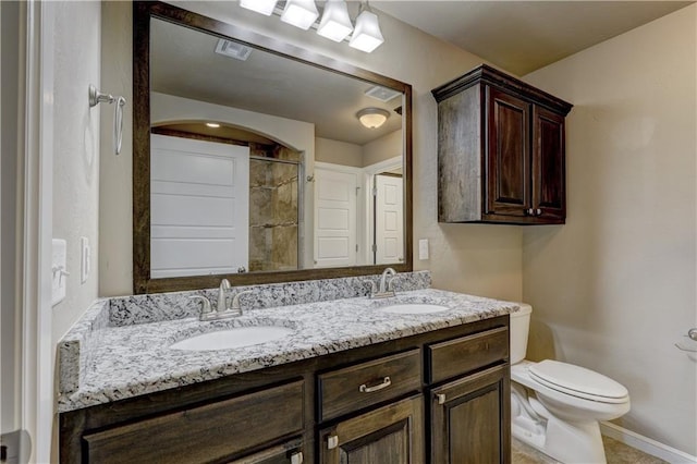 full bathroom with a sink, visible vents, toilet, and double vanity