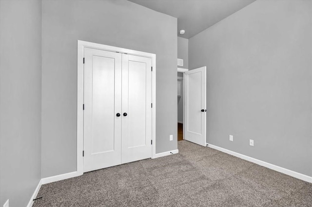 unfurnished bedroom with a closet, baseboards, and carpet floors