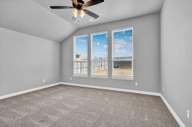 carpeted spare room with visible vents, baseboards, lofted ceiling, and a ceiling fan