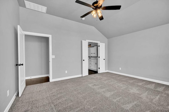 unfurnished bedroom featuring visible vents, ensuite bath, carpet, baseboards, and vaulted ceiling