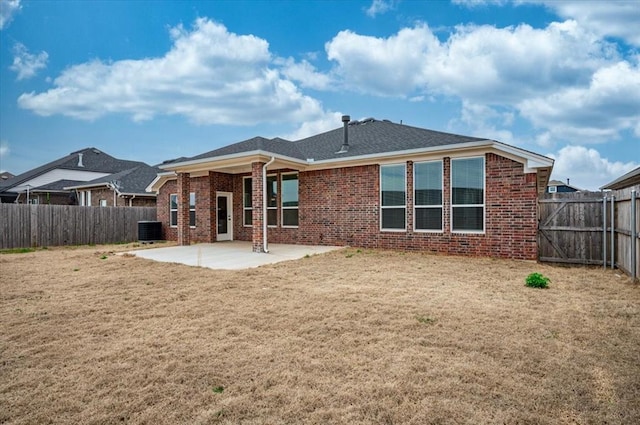 back of property with central AC, a patio area, brick siding, and a fenced backyard