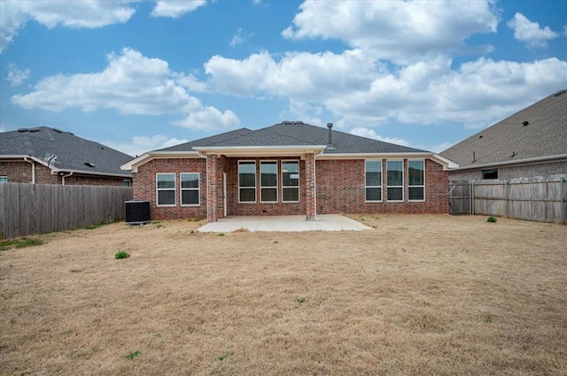 rear view of house with a patio, a fenced backyard, central AC, a lawn, and brick siding