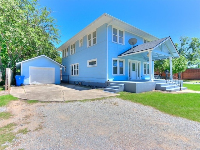 view of front of home with an outbuilding, concrete driveway, a detached garage, and a front lawn