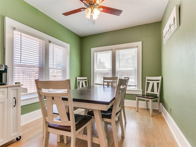 dining room with light wood finished floors, a healthy amount of sunlight, and baseboards