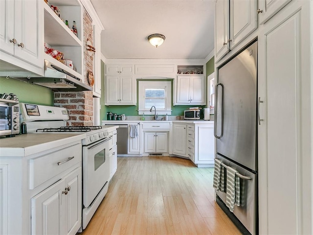 kitchen with open shelves, light countertops, appliances with stainless steel finishes, and a sink