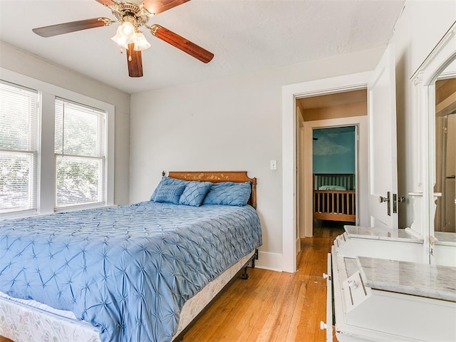 bedroom featuring baseboards, light wood-type flooring, and ceiling fan