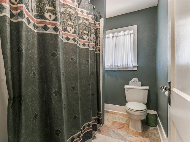 bathroom featuring toilet and baseboards