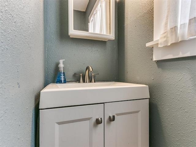 bathroom with vanity and a textured wall