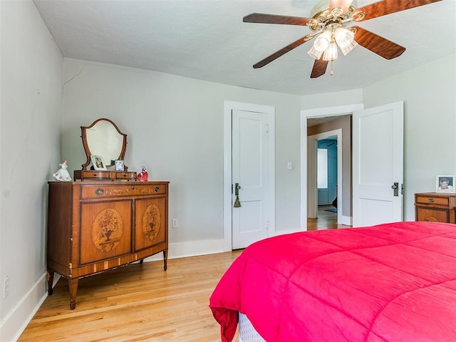 bedroom featuring baseboards, light wood-style floors, and ceiling fan