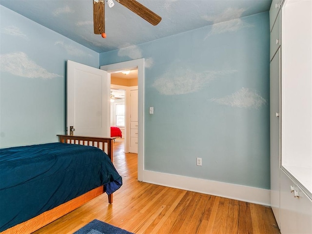 bedroom with a ceiling fan, light wood-style floors, and baseboards