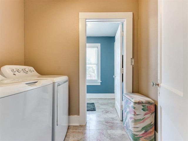 laundry area featuring washing machine and clothes dryer, laundry area, marble finish floor, and baseboards