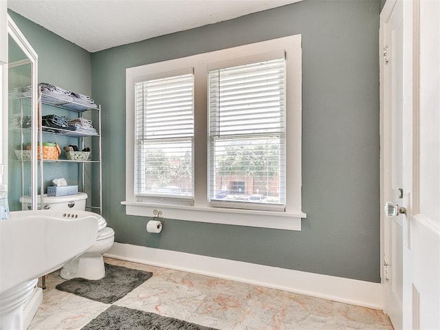 bathroom with baseboards and marble finish floor