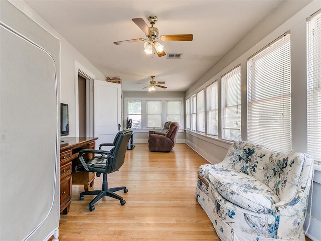 home office with visible vents, ceiling fan, baseboards, and light wood-style floors