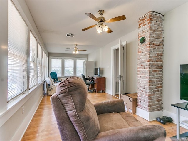 living area with visible vents, baseboards, ceiling fan, and light wood finished floors