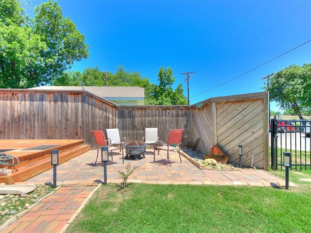 view of patio / terrace featuring a jacuzzi, a fire pit, and a fenced backyard