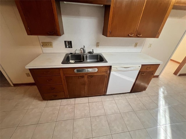 kitchen featuring light tile patterned floors, a sink, light countertops, and white dishwasher