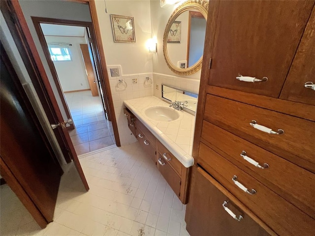 bathroom featuring tile walls, wainscoting, and vanity