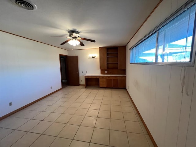 spare room with visible vents, a ceiling fan, light tile patterned floors, baseboards, and built in study area