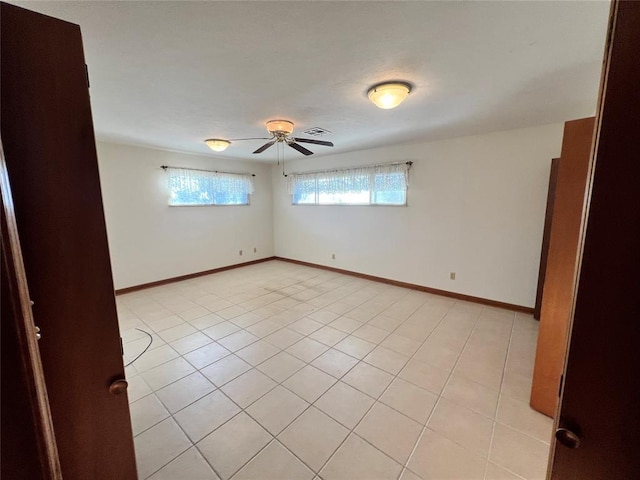 spare room featuring visible vents, baseboards, ceiling fan, and light tile patterned flooring