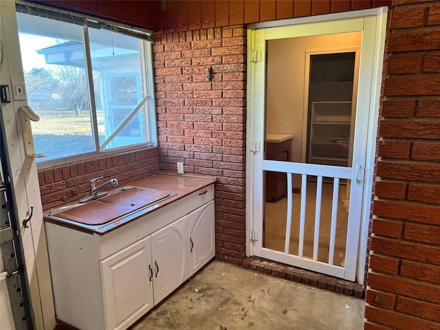 bathroom with brick wall and a sink