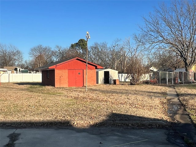 view of yard with a pole building, an outdoor structure, and fence