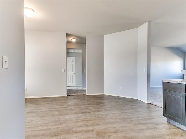 unfurnished room with light wood-style flooring and baseboards