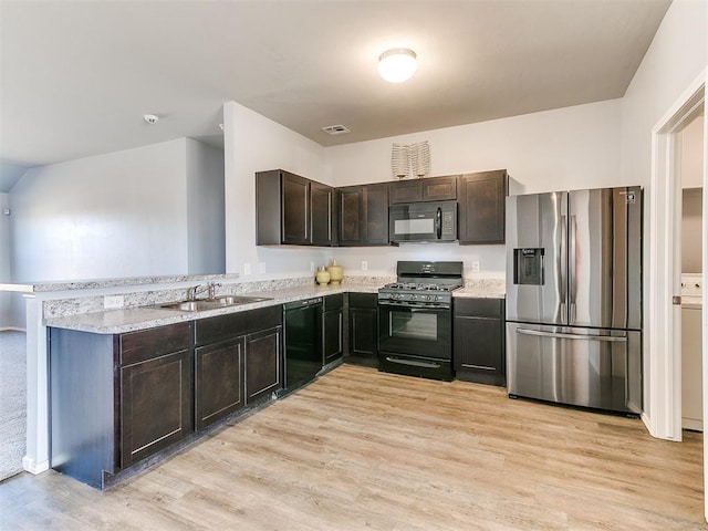 kitchen featuring dark brown cabinets, light wood-type flooring, a peninsula, black appliances, and a sink