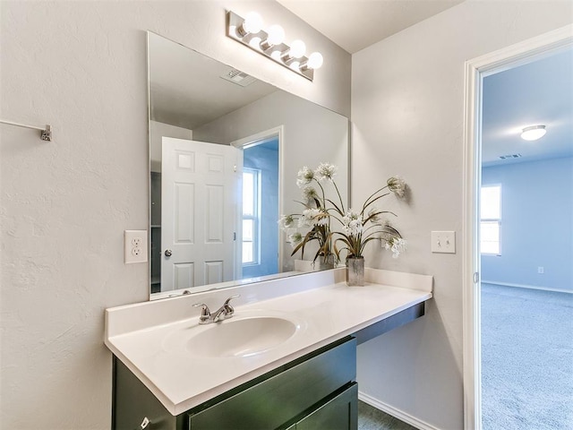 bathroom with vanity, baseboards, and visible vents