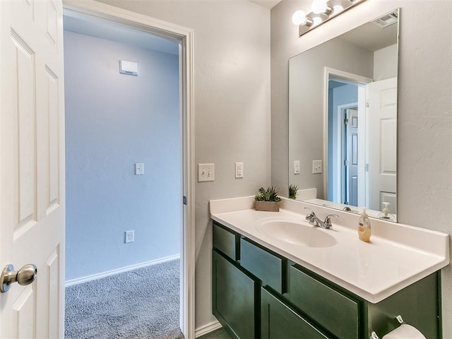 bathroom with visible vents, baseboards, and vanity