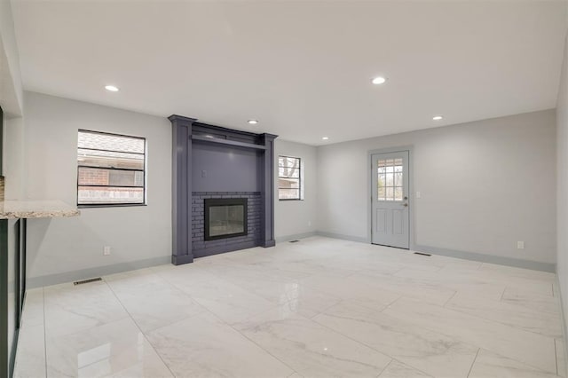 unfurnished living room with visible vents, recessed lighting, and a fireplace