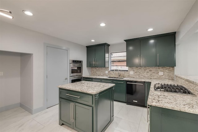 kitchen featuring marble finish floor, a sink, tasteful backsplash, stainless steel appliances, and green cabinets