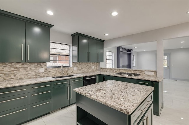 kitchen featuring a sink, backsplash, green cabinets, light stone countertops, and stainless steel gas cooktop